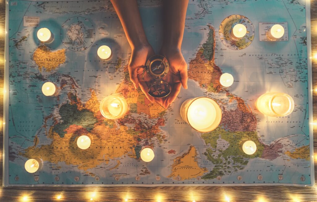 Top view female hands planning vacation tour equipped with world map and vintage nautical compass